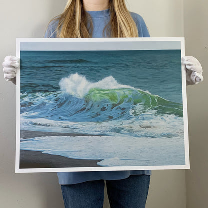 an artist holding a limited edition print of an ocean wave oil painting